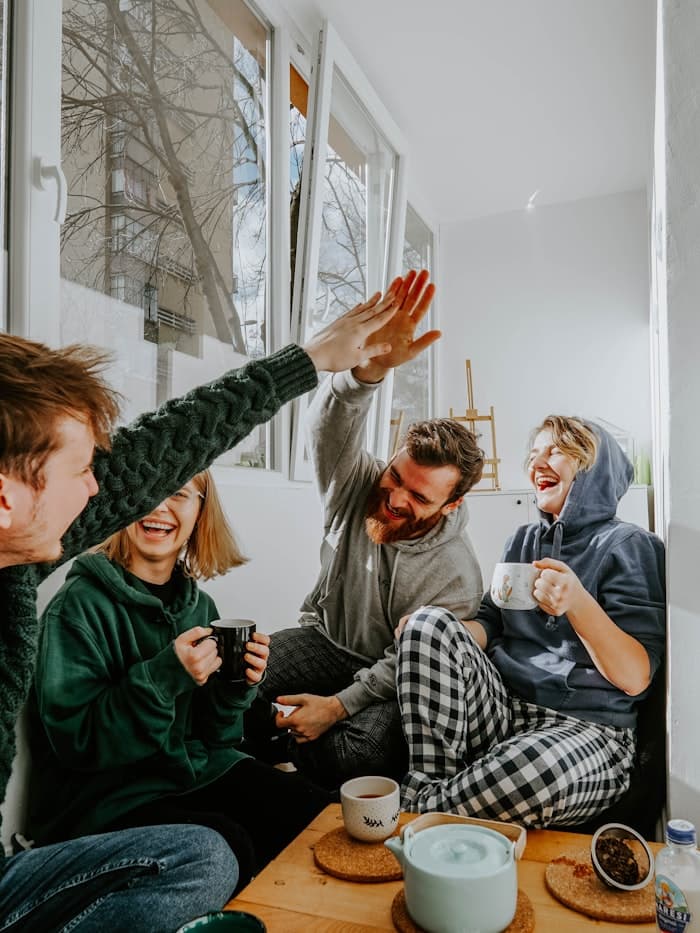 Friends laughing together over tea